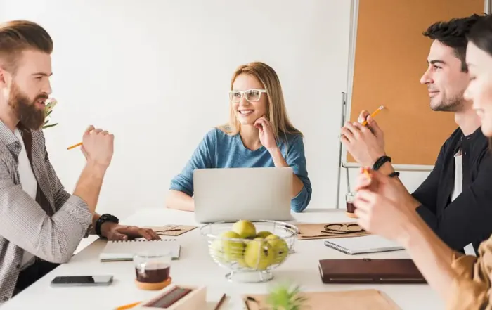 Personen sitzen gemeinsam am Tisch und planen Projekte. Multiprojektmanagement.
