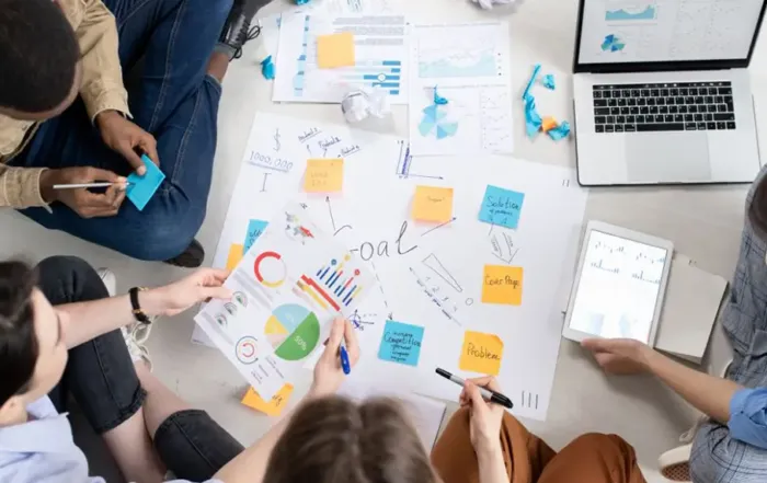 Tisch mit Personen, die Projektmanagement Methoden diskutieren