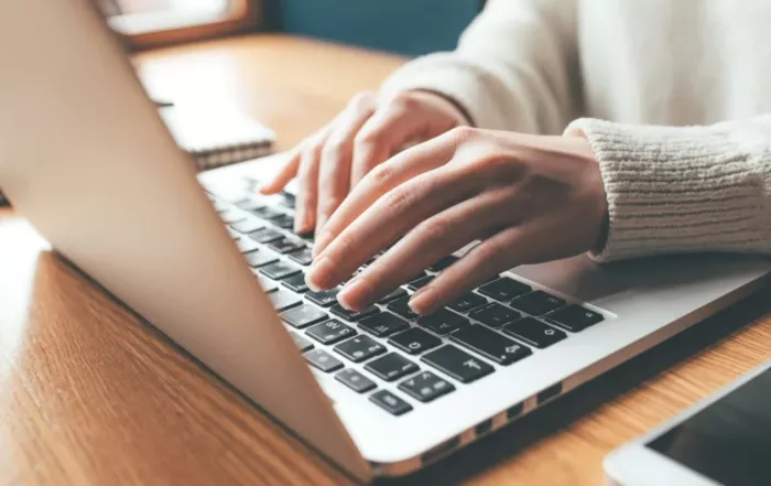 Person arbeitet am Laptop mit KI-Tools im Projektmanagement