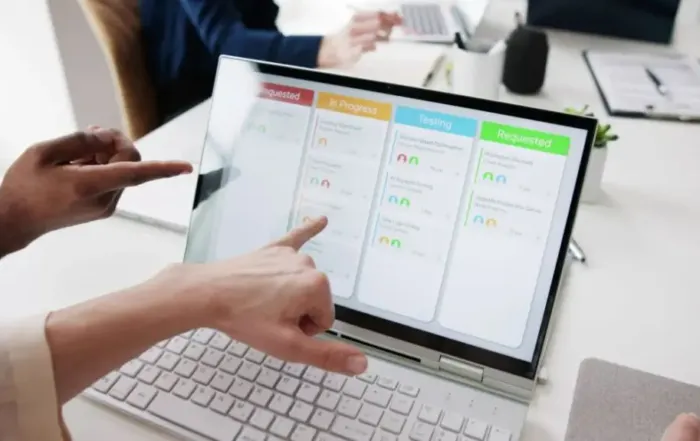 Finger zeigen auf einen Laptop der ein Projektmanagement Tool zeigt